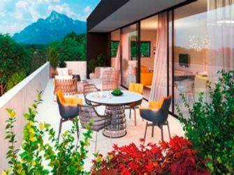 Große Terrasse mit Sitzgelegenheiten, üppiger Bepflanzung und Bergblick.