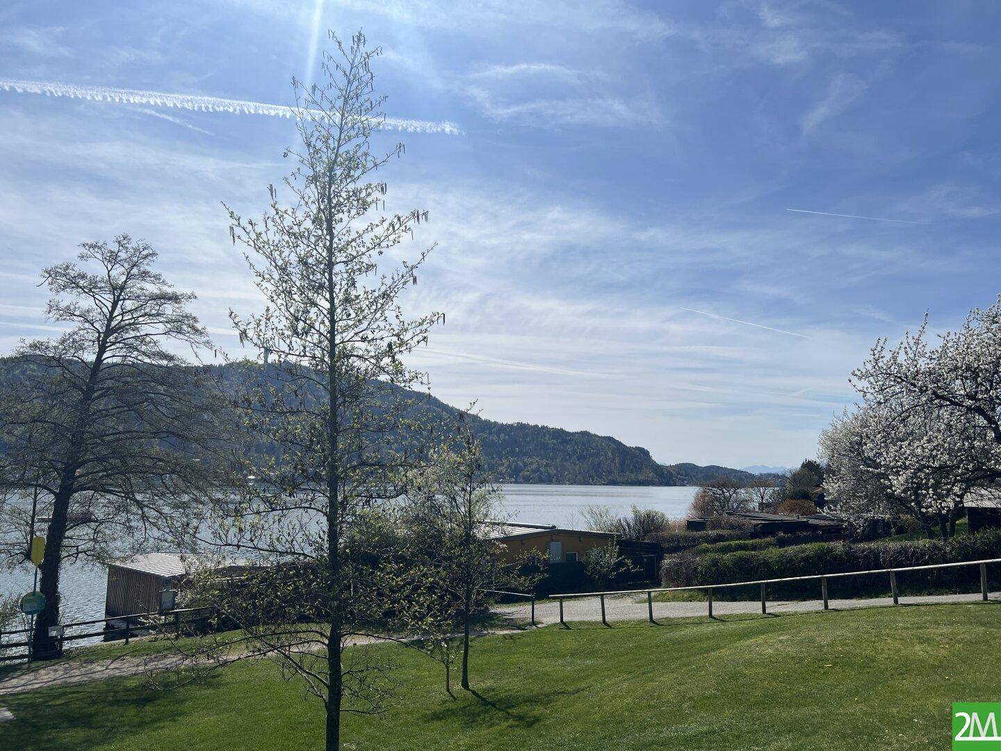 Malerischer Blick auf den See und die umliegende Natur unter blauem Himmel.