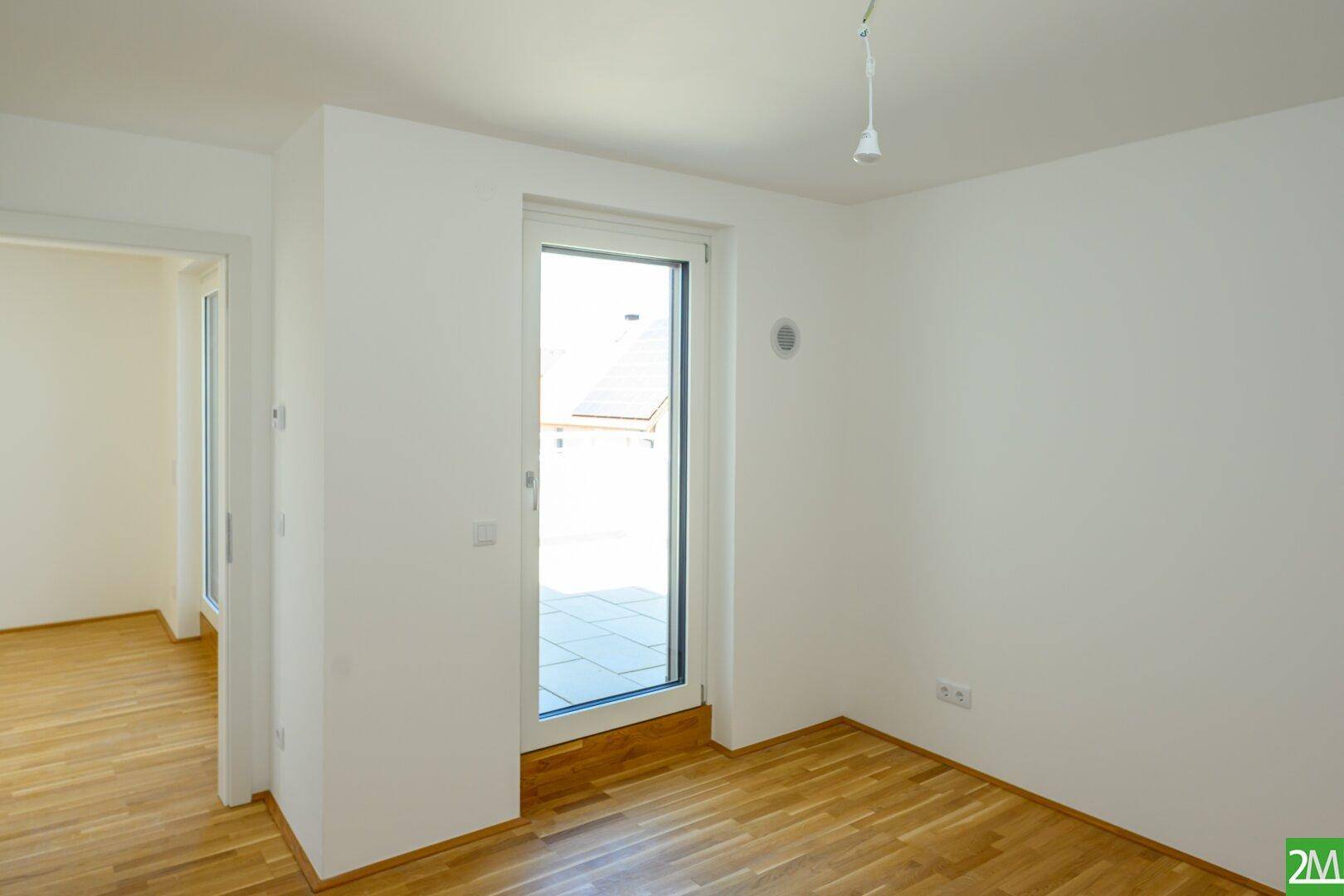 Heller Raum mit Holzboden und Zugang zu einem Außenbereich, ideal für individuelle Gestaltung.