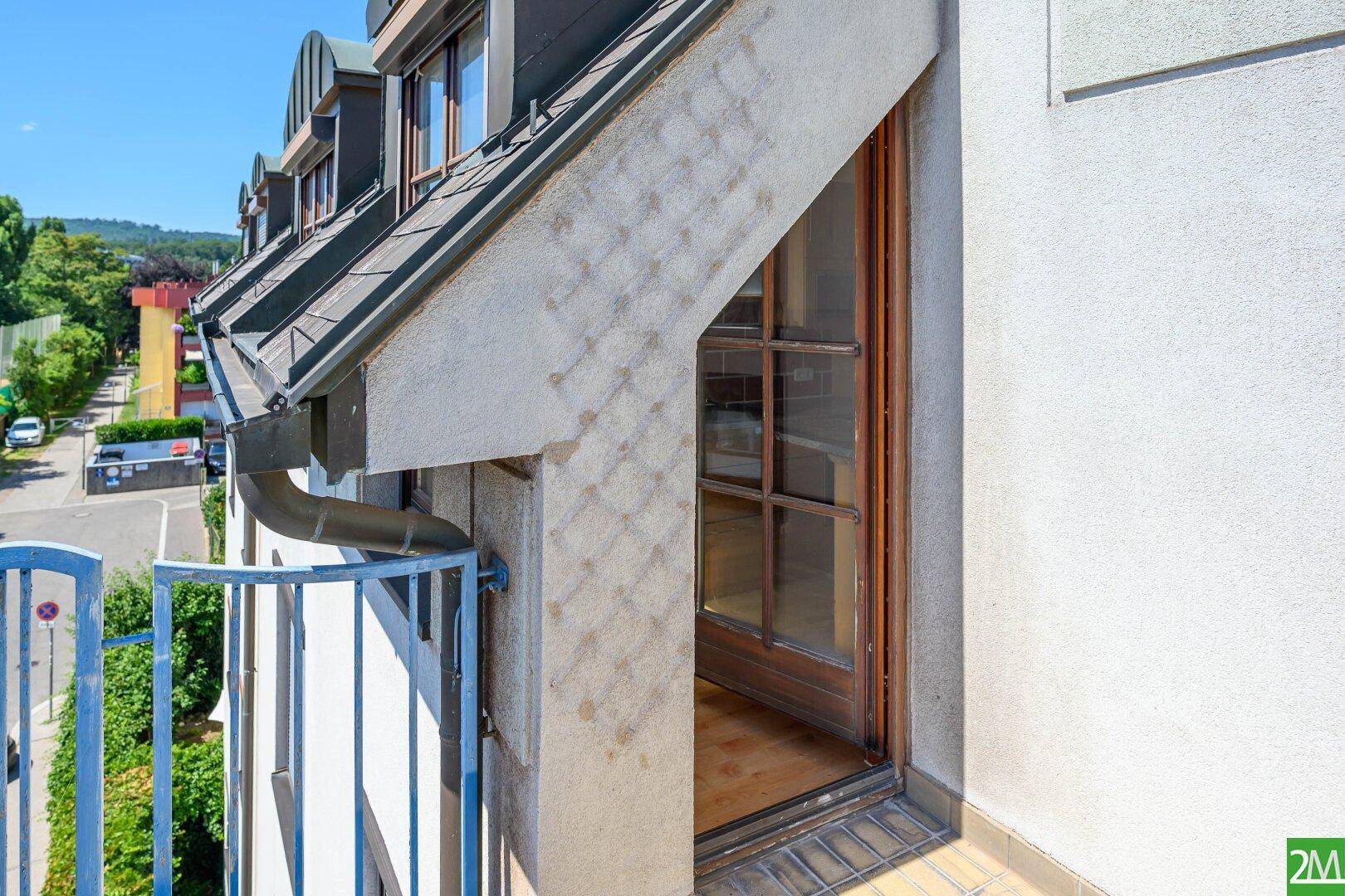 Kleiner Balkon mit Zugang zum Innenraum und Blick auf die grüne Umgebung.