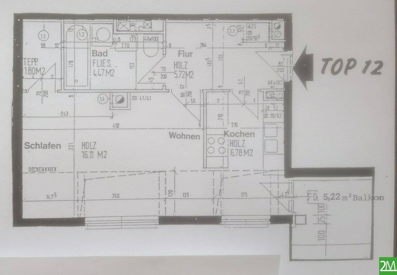 Grundriss der Wohnung "Top 12" mit Schlafzimmer, Wohnbereich, Küche und Balkon.