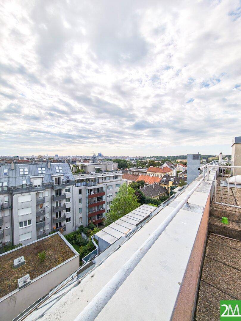 Weitläufiger Blick von einer Dachterrasse über die Stadt und umliegende Gebäude.
