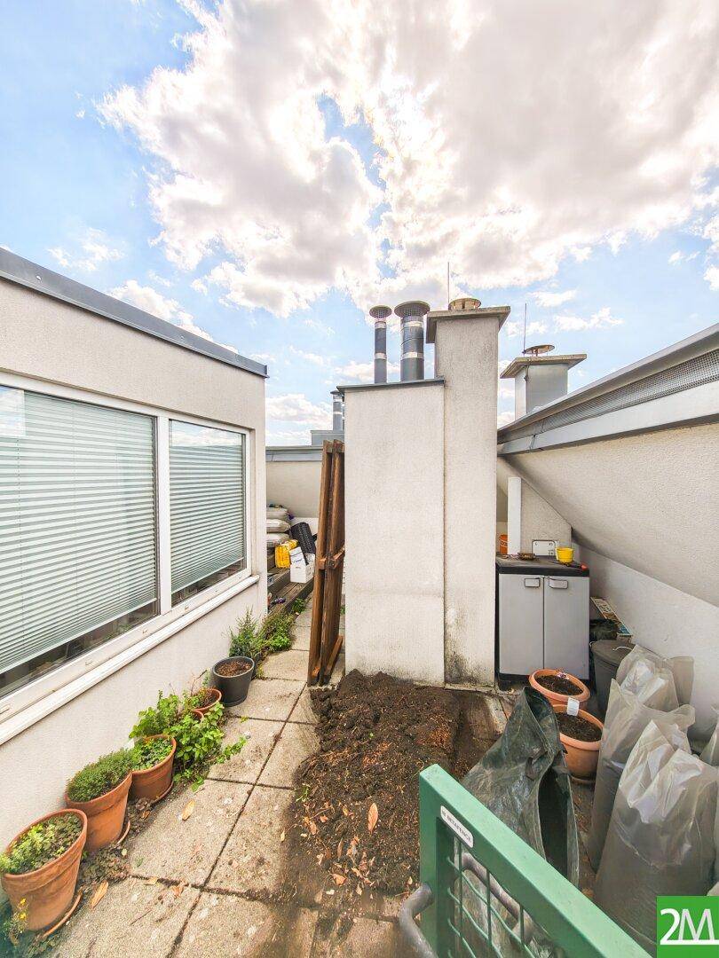 Nutzbereich auf der Dachterrasse mit Abstellmöglichkeiten und gepflastertem Boden.