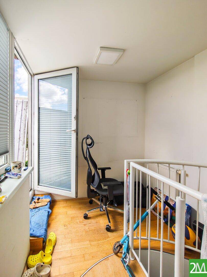 Kleiner Raum mit Holzboden und Zugang zu einem Außenbereich, vielseitig nutzbar.
