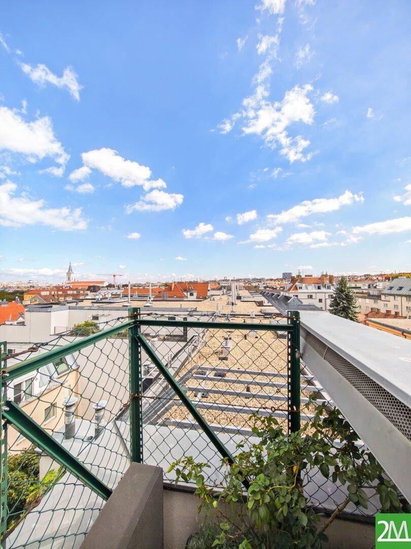 Panoramablick von der Dachterrasse über die Dächer der Stadt unter blauem Himmel.
