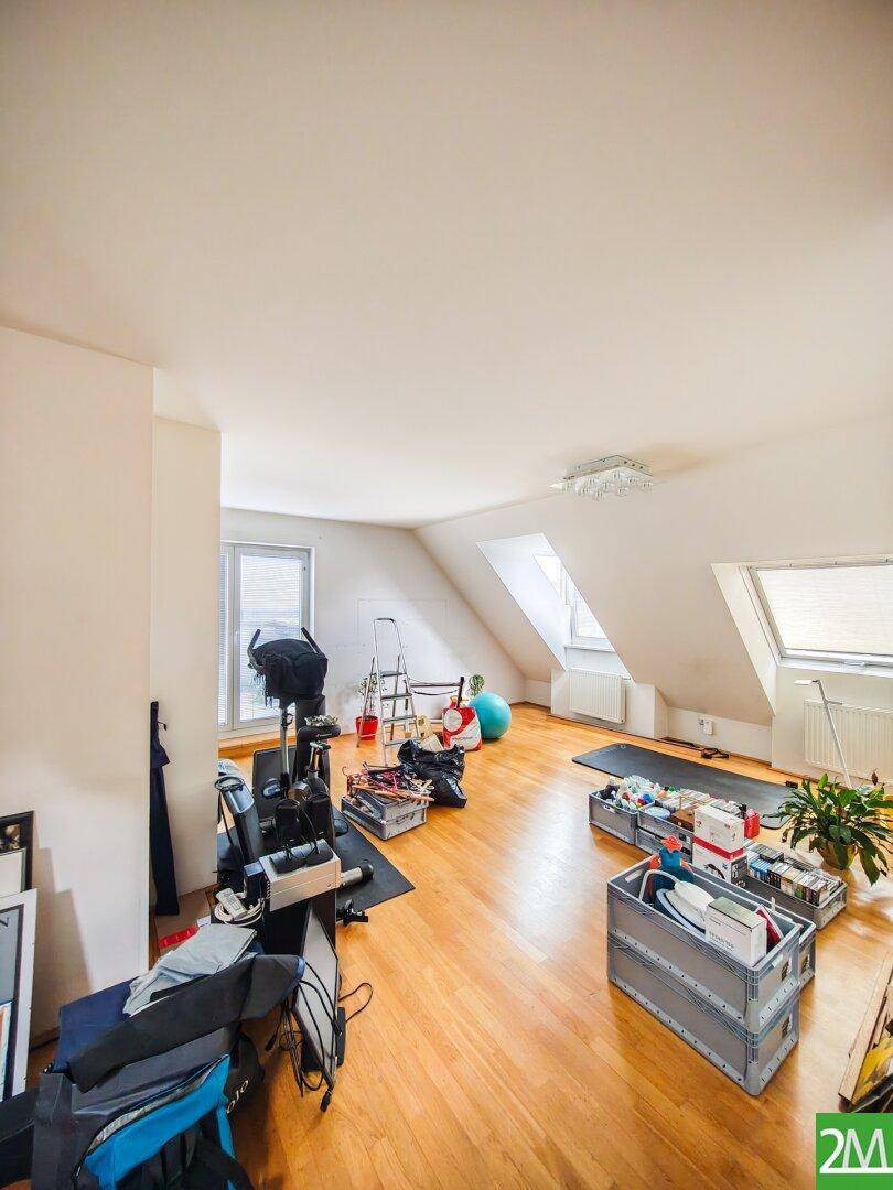 Heller Dachbodenraum mit Holzboden und Dachfenstern, derzeit als Abstell- und Fitnessbereich genutzt.