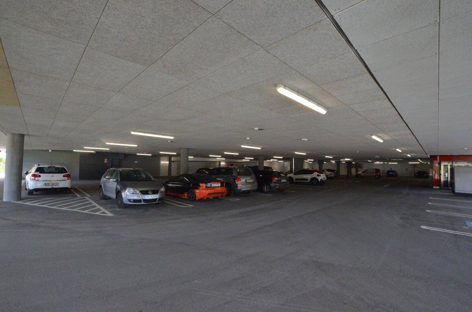 Geräumige Tiefgarage mit vielen Stellplätzen und heller Beleuchtung.