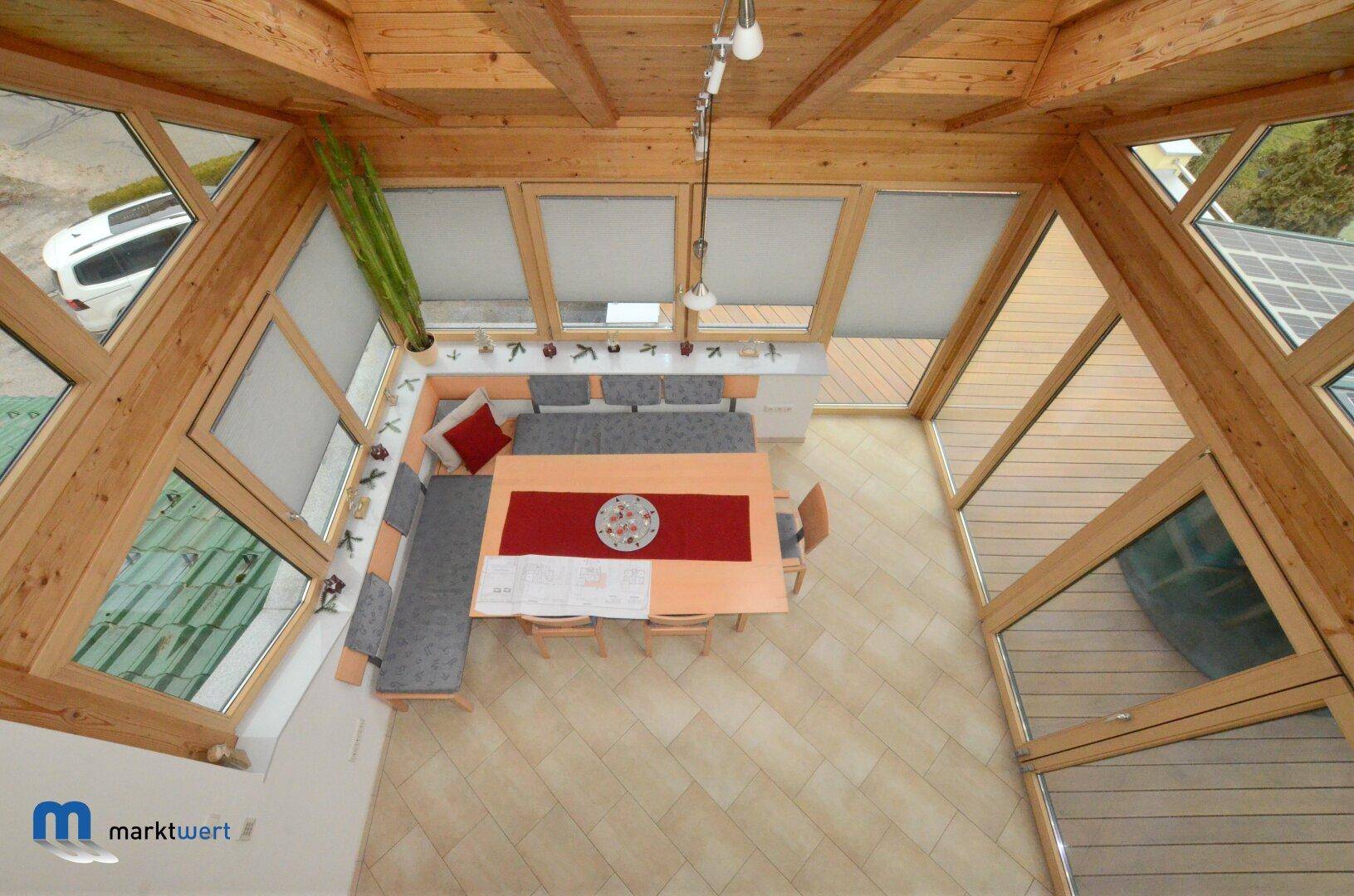 Heller Essbereich mit Holzbalkendecke, großen Fenstern und gemütlicher Eckbank.