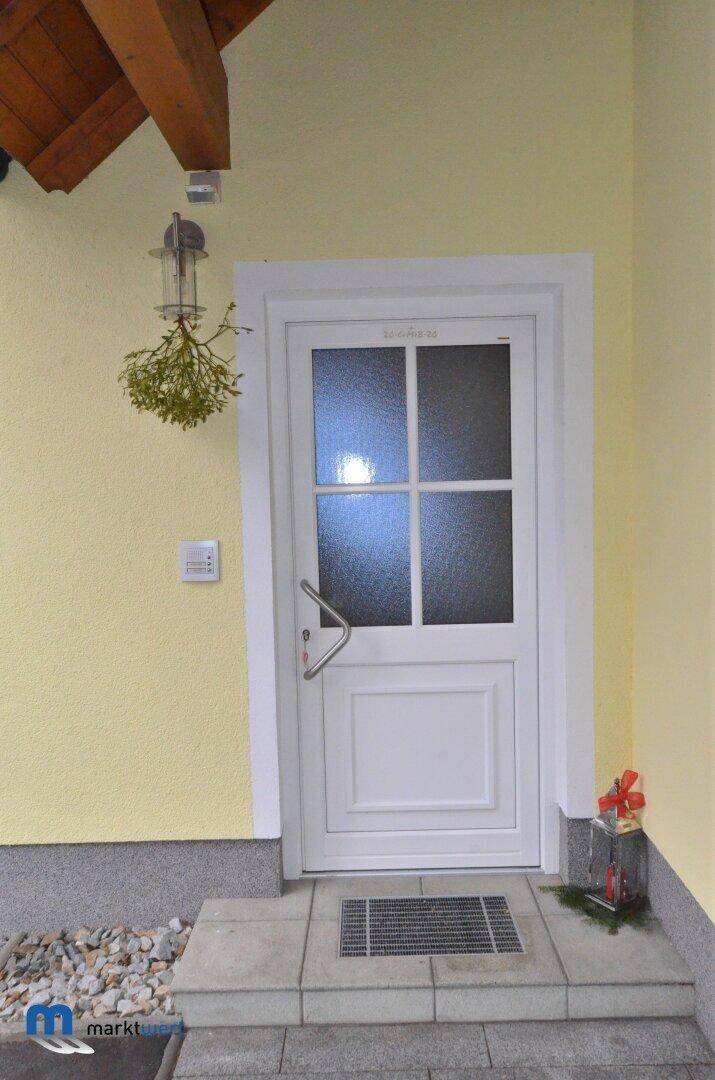 Heller Eingangsbereich mit weißer Haustür und kleinen Dekorationselementen.