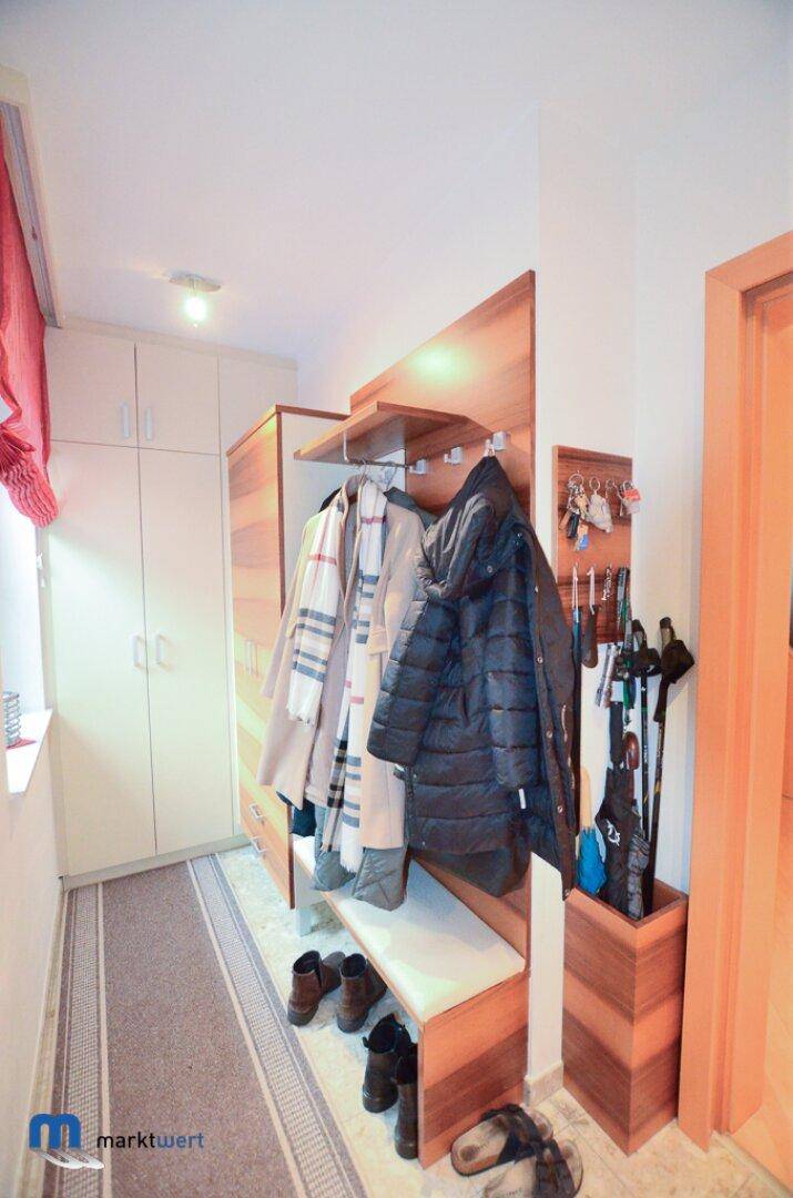 Praktischer Flur mit Garderobe, Sitzbank und Stauraum für Schuhe und Accessoires.
