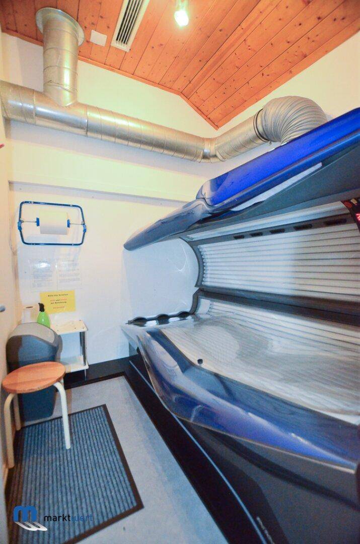 Raum mit Solarium, Holzdecke und sichtbaren Lüftungsrohren für Entspannung.