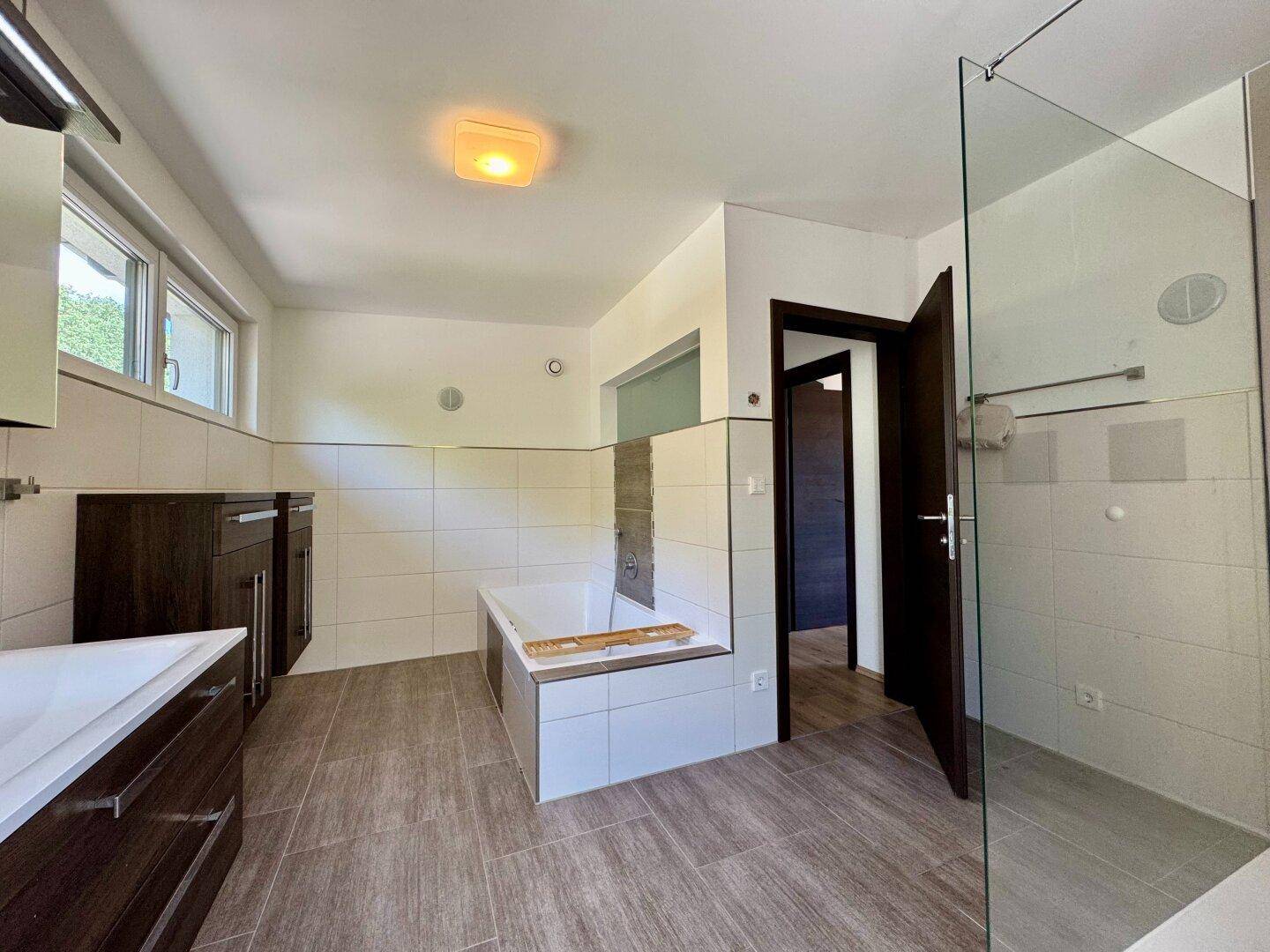 Geräumiges Badezimmer mit Badewanne, modernen Fliesen und viel Platz.