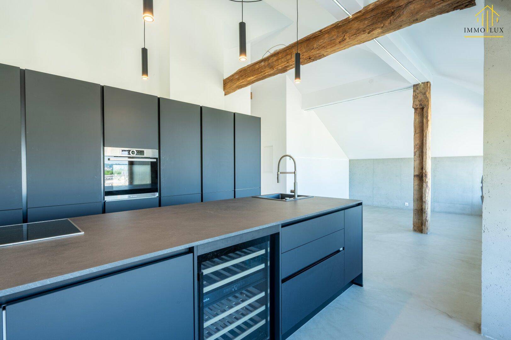 Moderne Einbauküche mit Kochinsel, integrierten Geräten und Weinkühler.