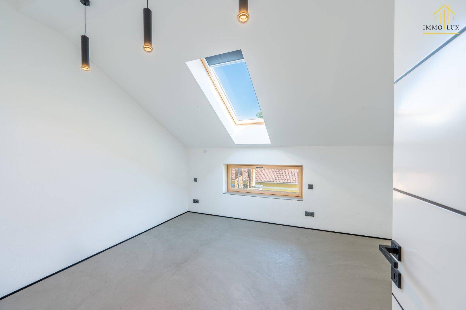 Lichtdurchflutetes Zimmer mit Dachfenster, kleinem Fenster und moderner Beleuchtung.