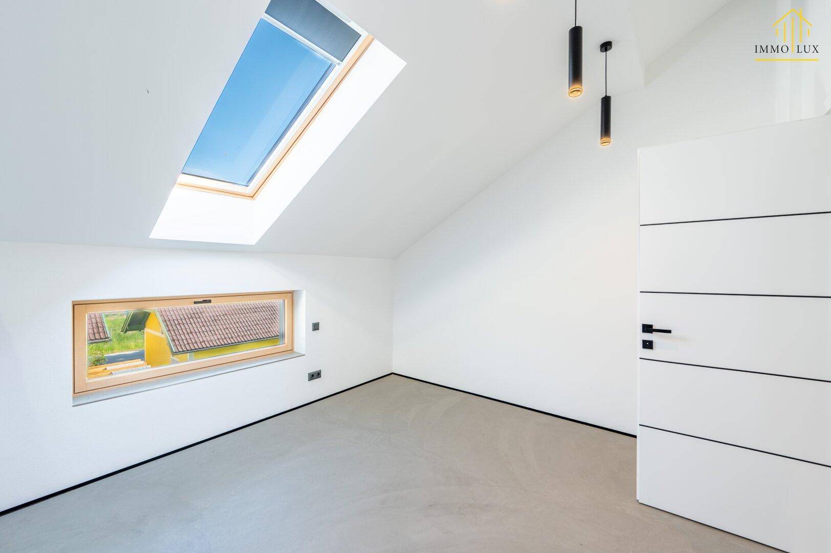 Helles Zimmer mit Dachfenster, Ausblick und moderner Türgestaltung.
