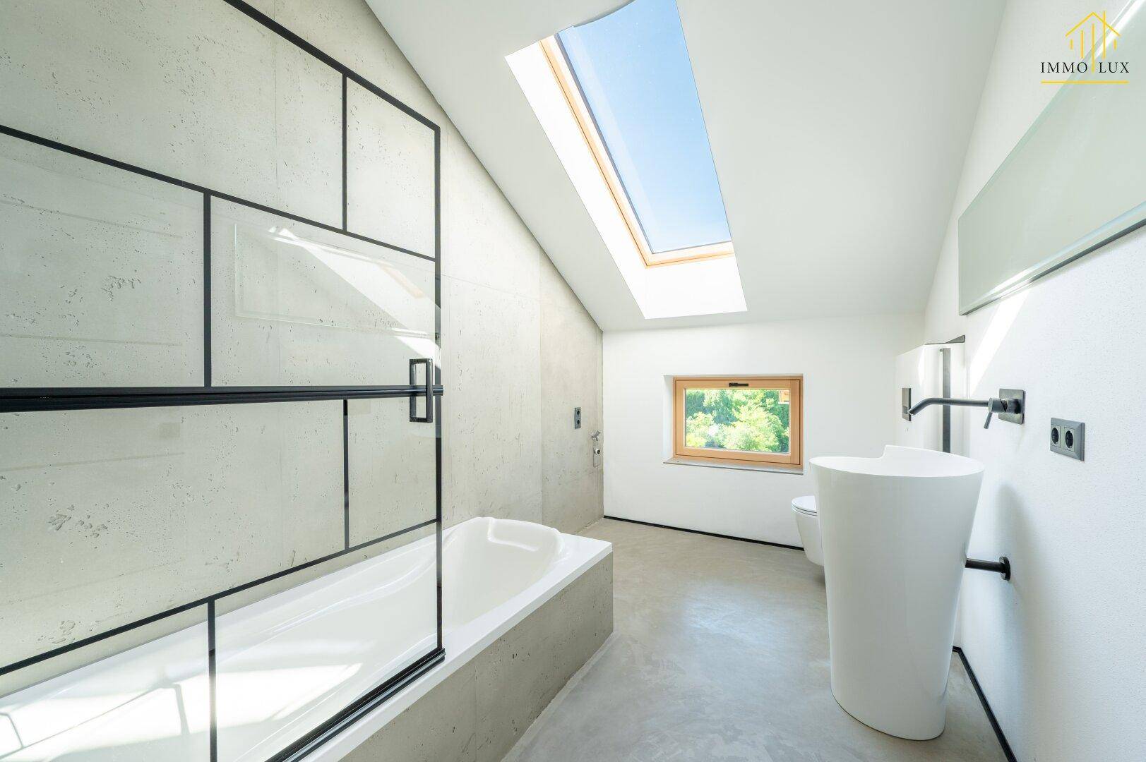 Modernes Badezimmer mit Badewanne, Dusche, Dachfenster und stilvollem Waschbecken.