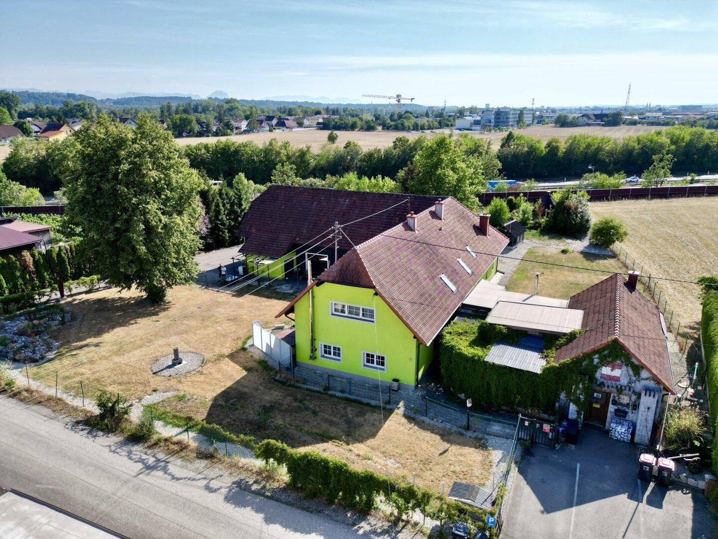 Luftaufnahme des Anwesens mit Hauptgebäude, Nebengebäude und weitläufigen Grünflächen in ländlicher Umgebung.