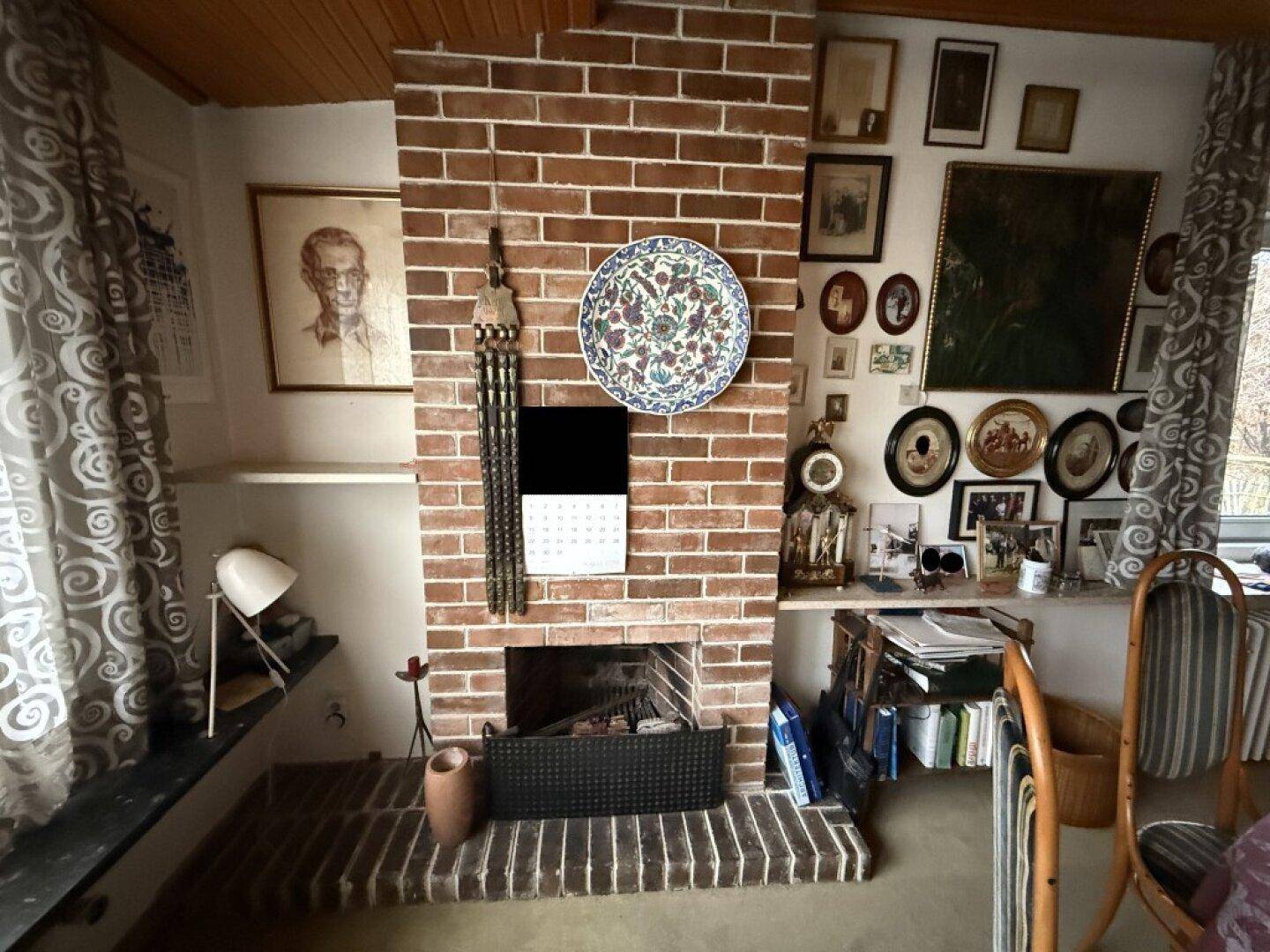 Rustikaler Kamin aus Ziegelstein als Mittelpunkt des Raumes, umgeben von persönlichen Dekorationen.