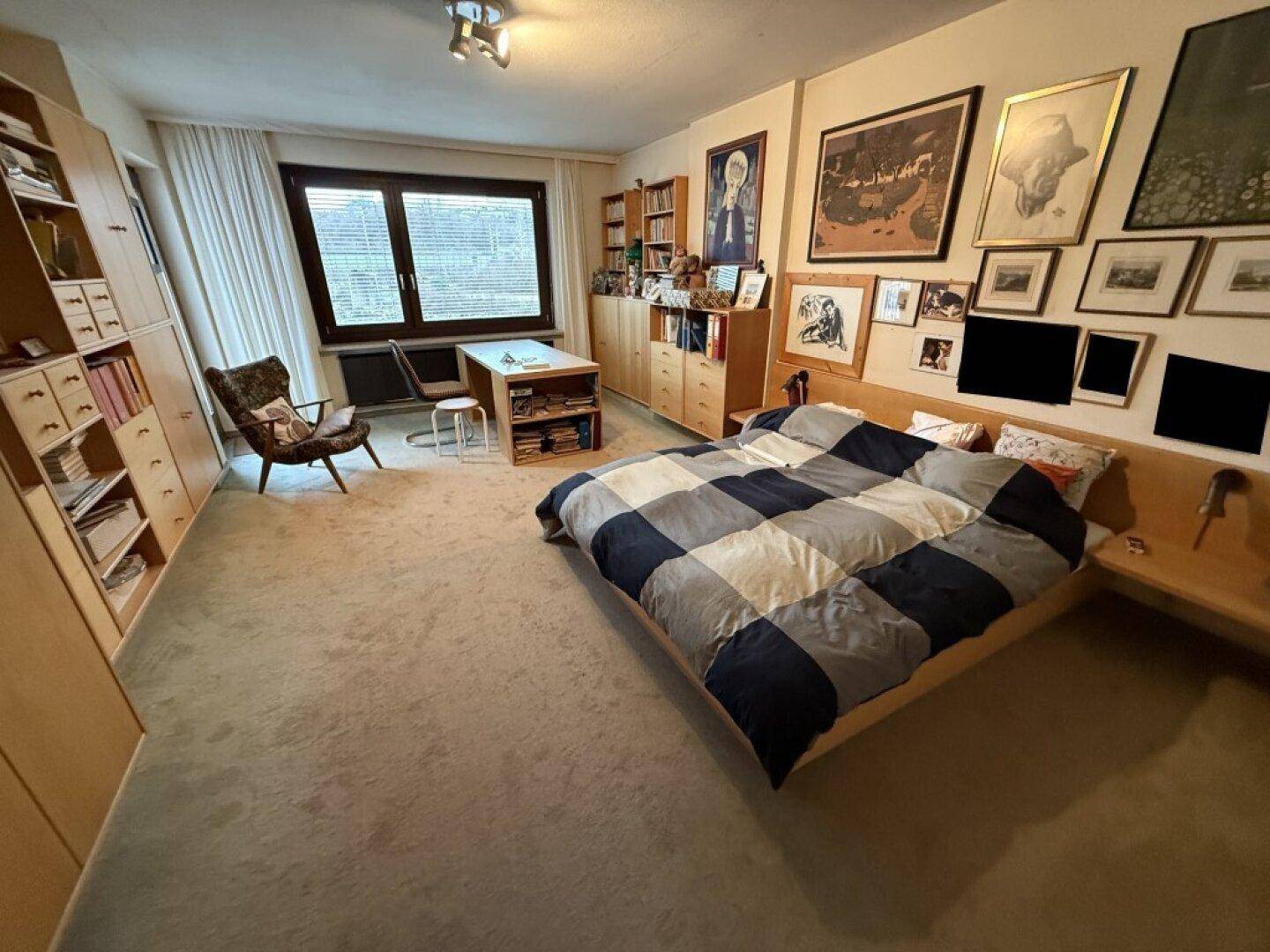 Geräumiges Schlafzimmer mit Doppelbett, Teppichboden und einem großen Fenster für viel Tageslicht.