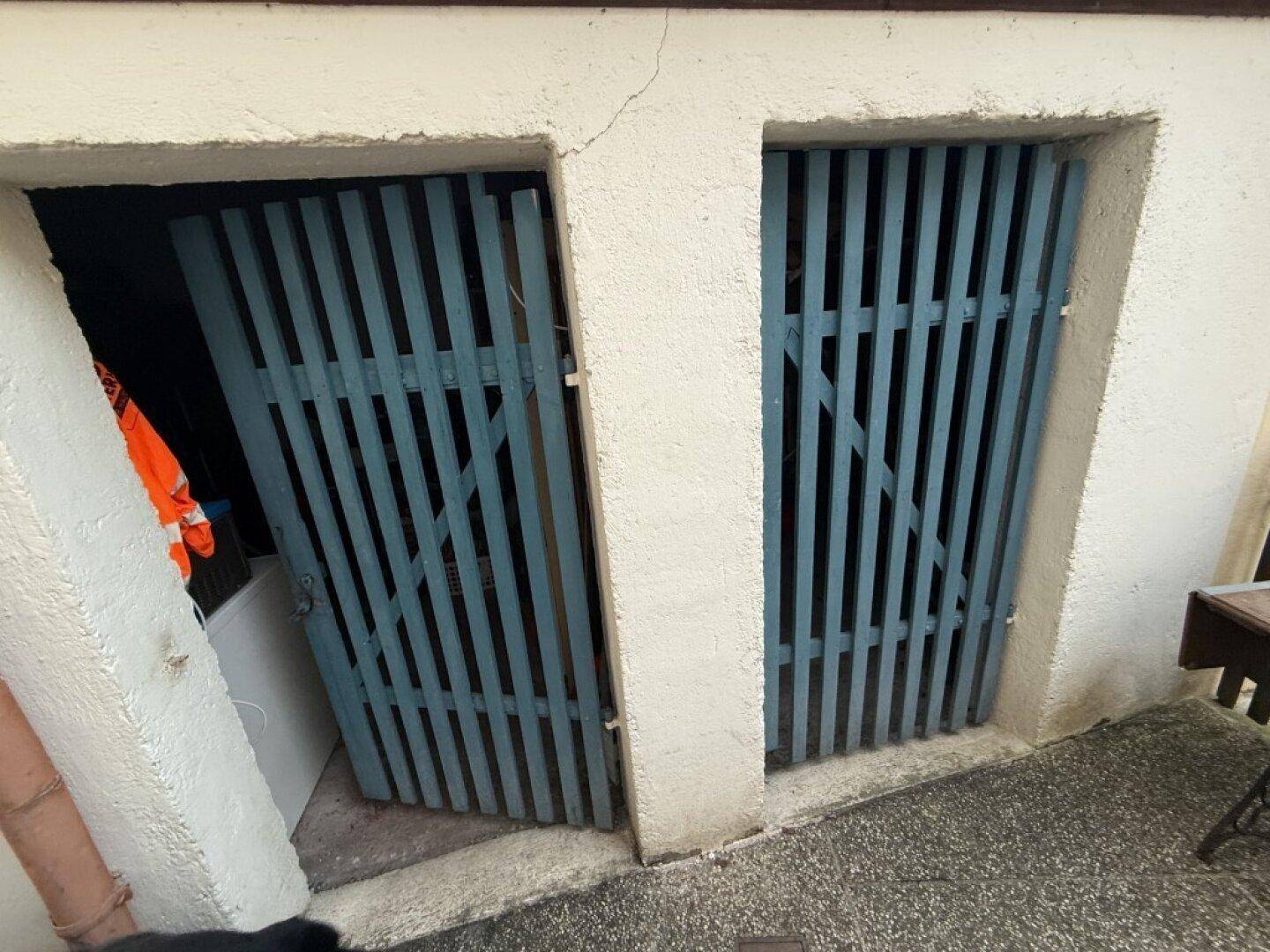 Zwei kleine Holztüren, die zu Abstellräumen oder einem Kellerabteil führen.