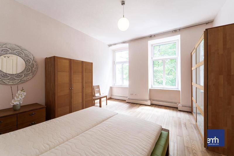 Geräumiges Schlafzimmer mit Holzboden, großen Fenstern und viel Tageslicht.