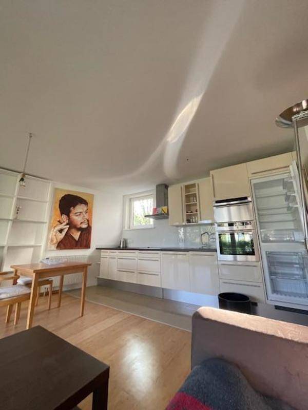 Moderne Einbauküche mit hellen Schränken, integrierten Geräten und Essbereich im offenen Wohnraum.