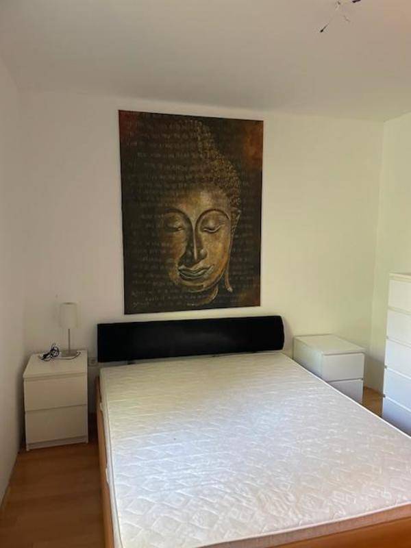Schlafzimmer mit Doppelbett, Nachttischen und einem großen Kunstwerk an der Wand.