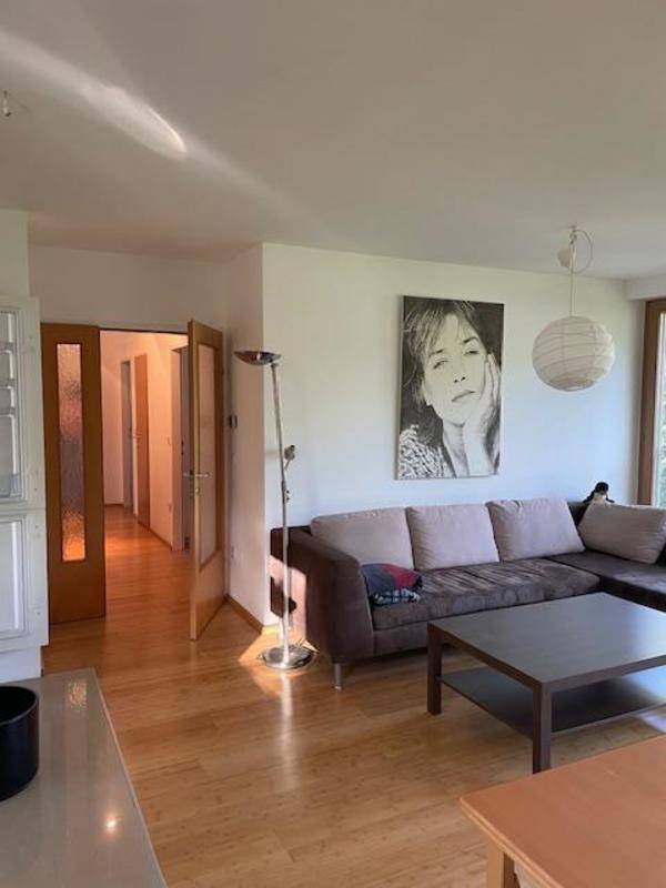 Gemütliches Wohnzimmer mit Sofa und Blick in den angrenzenden Flurbereich.