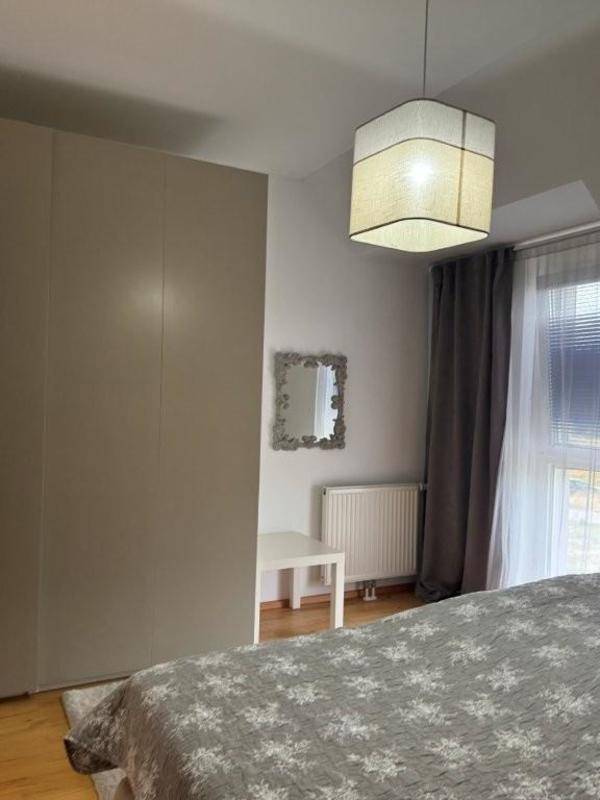 Schlafzimmer mit großem Kleiderschrank, Fenster und Heizkörper.