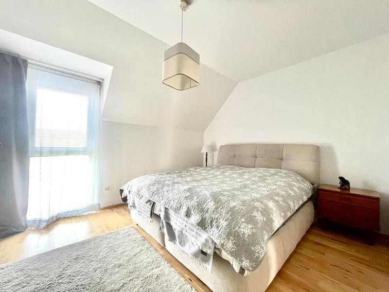 Gemütliches Schlafzimmer mit Dachschräge, Doppelbett und Holzboden.