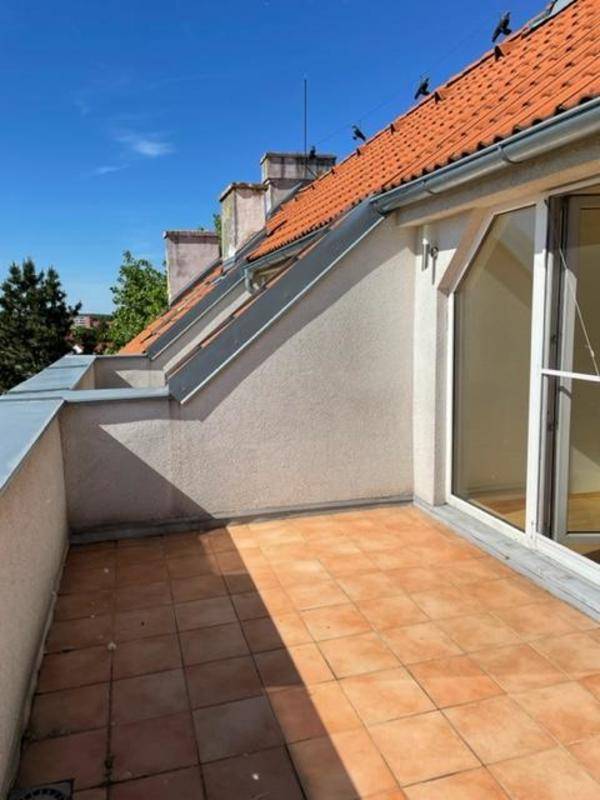 Sonniger Dachterrasse mit Terrakotta-Fliesen und Blick auf die Dächer der Umgebung.