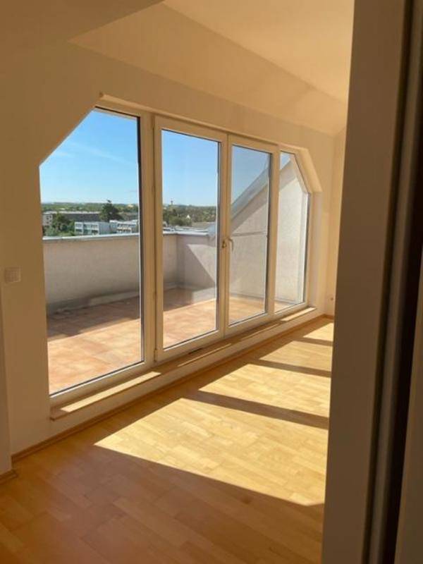 Heller Raum mit Zugang zu einer Terrasse und Blick auf die Umgebung.