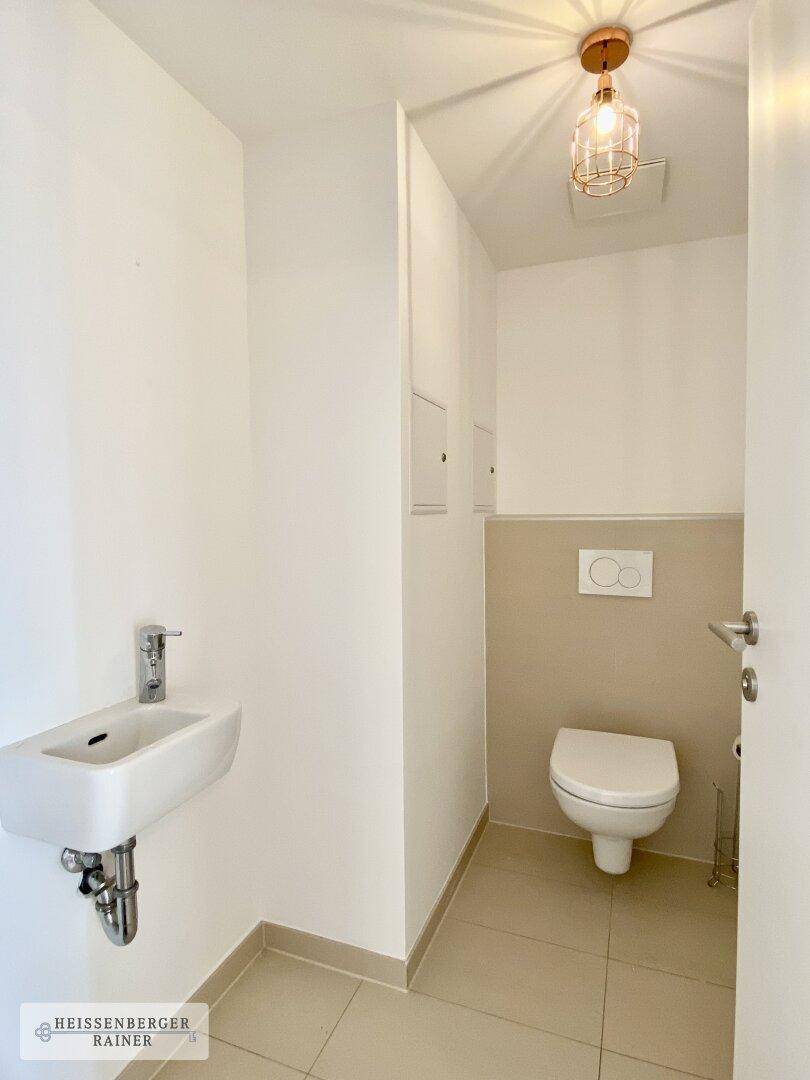Gäste-WC mit modernem Waschbecken und wandhängender Toilette.