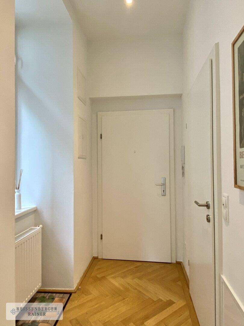 Eingangsbereich der Wohnung mit heller Tür und Parkettboden, sauber und gepflegt.