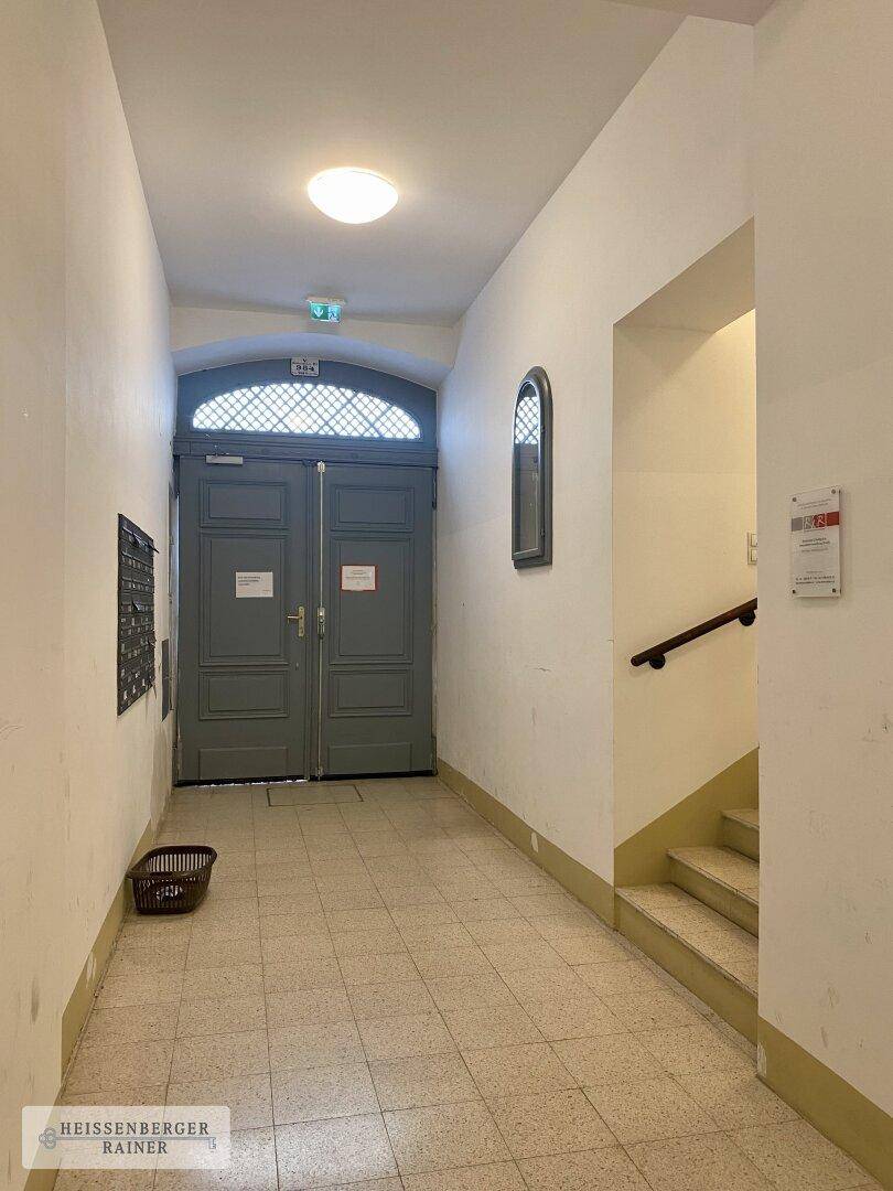 Historischer Eingangsbereich des Gebäudes mit Doppeltür und Treppenaufgang, charmant und klassisch.