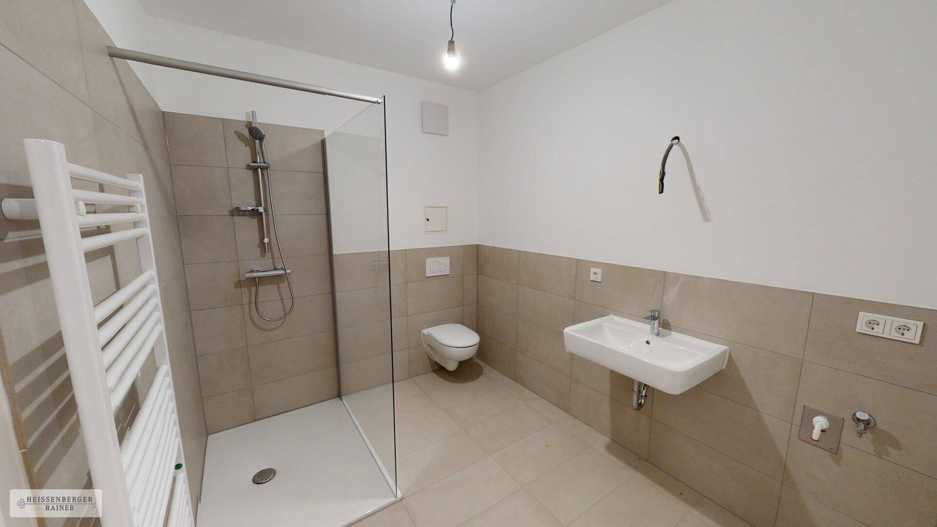 Modernes Badezimmer mit begehbarer Dusche, Wand-WC und Handtuchheizkörper.