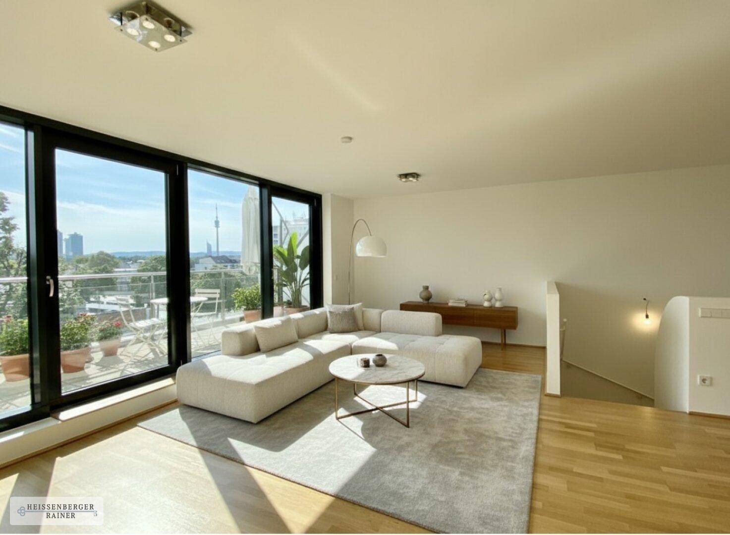 Geräumiges Wohnzimmer mit bodentiefen Fenstern, hellem Holzboden und moderner Couch.