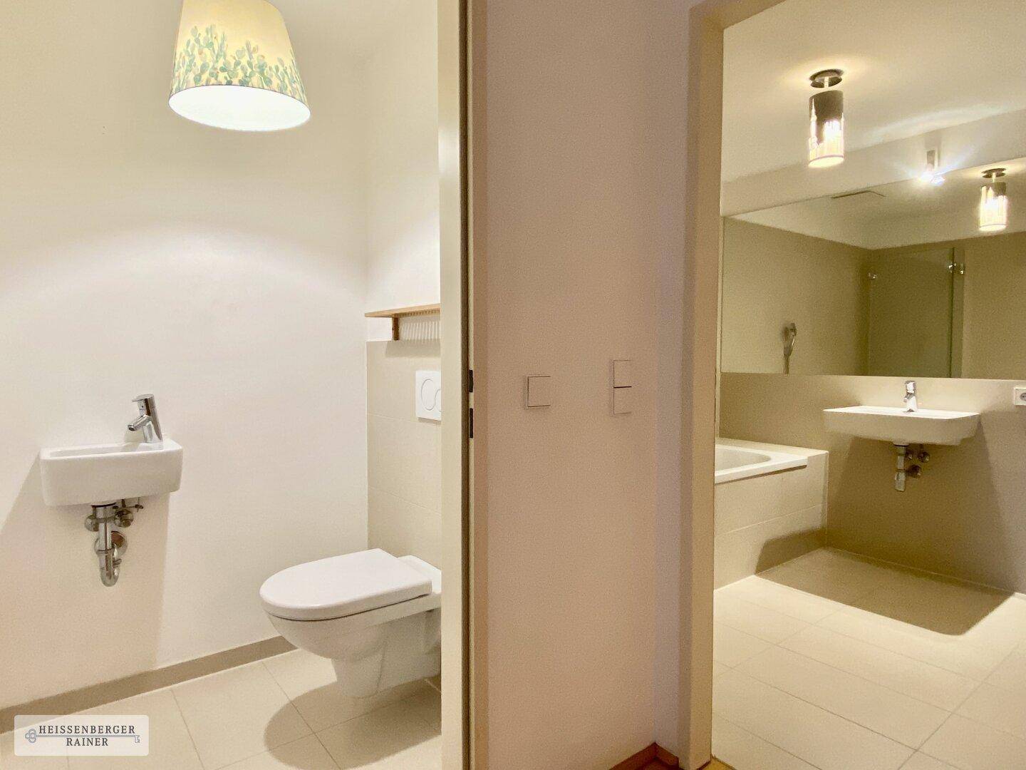 Separates Gäste-WC mit Toilette und kleinem Waschbecken, direkt neben dem Hauptbadezimmer.