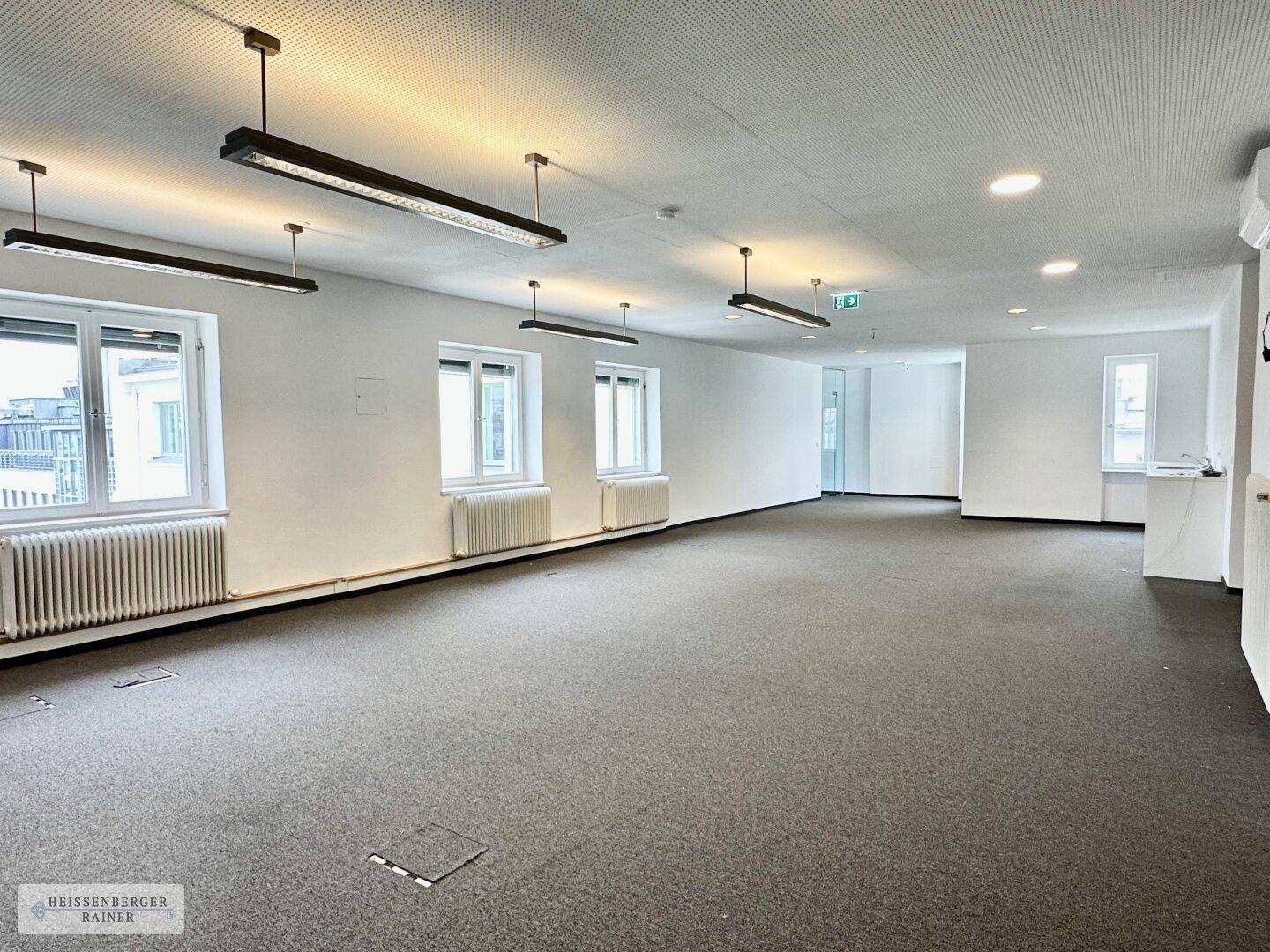 Heller und geräumiger Bürobereich mit Teppichboden, vielen Fenstern und moderner Beleuchtung, bereit zur individuellen Gestaltung.