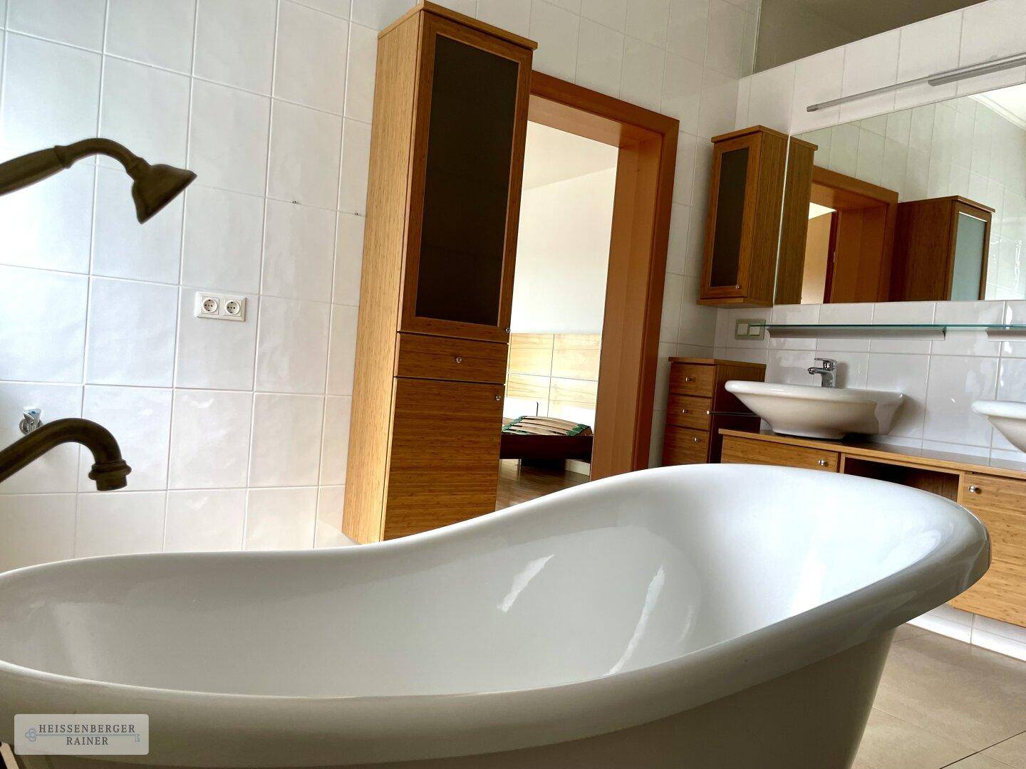 Badezimmer mit Blick auf das angrenzende Schlafzimmer, ausgestattet mit freistehender Badewanne.