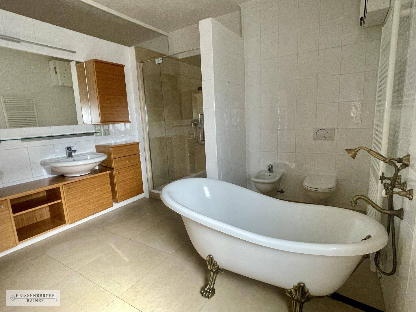 Helles Badezimmer mit freistehender Badewanne, begehbarer Dusche und Doppelwaschbecken.
