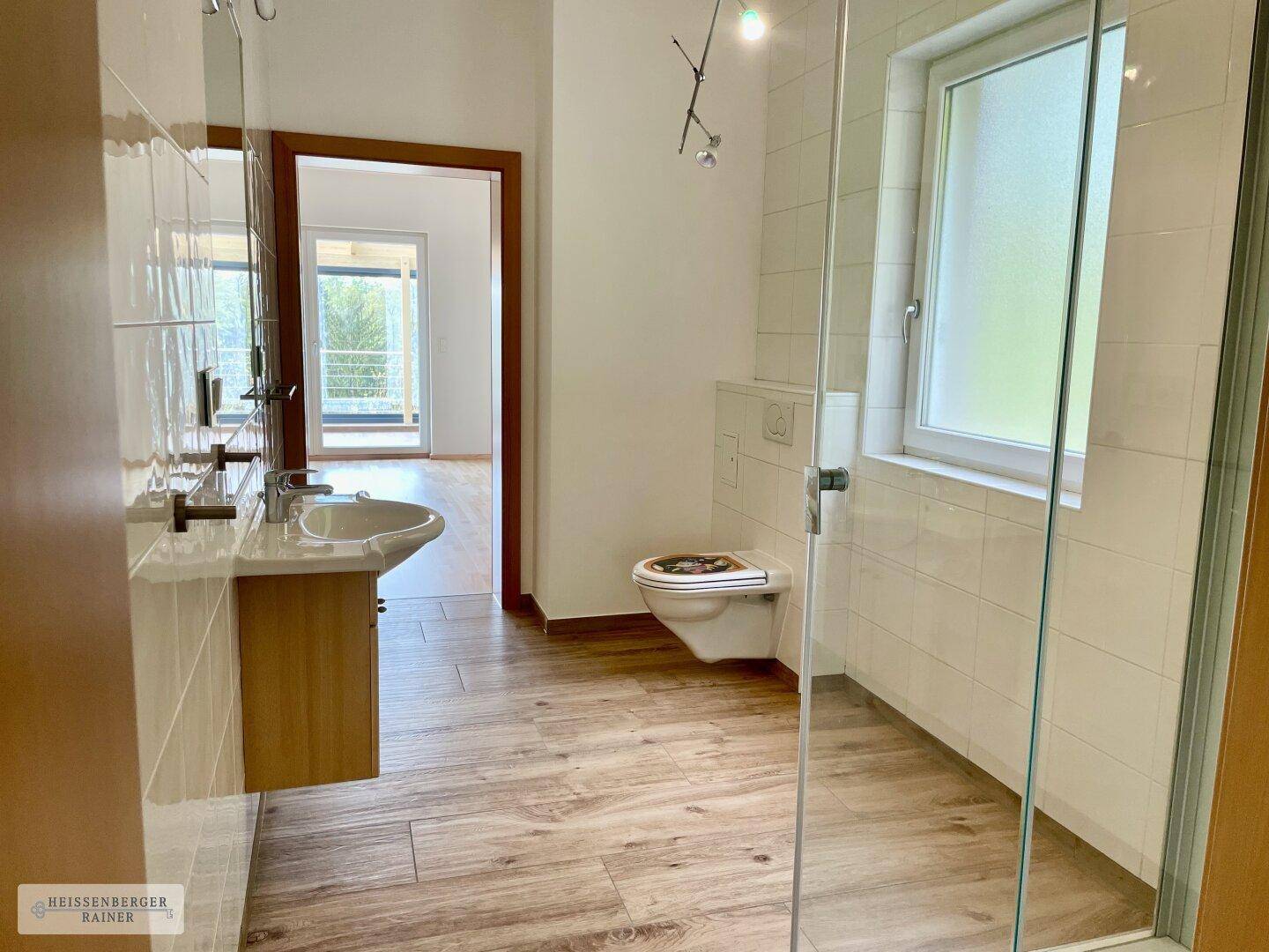 Modernes Badezimmer mit Dusche, wandhängendem WC und Einzelwaschbecken.