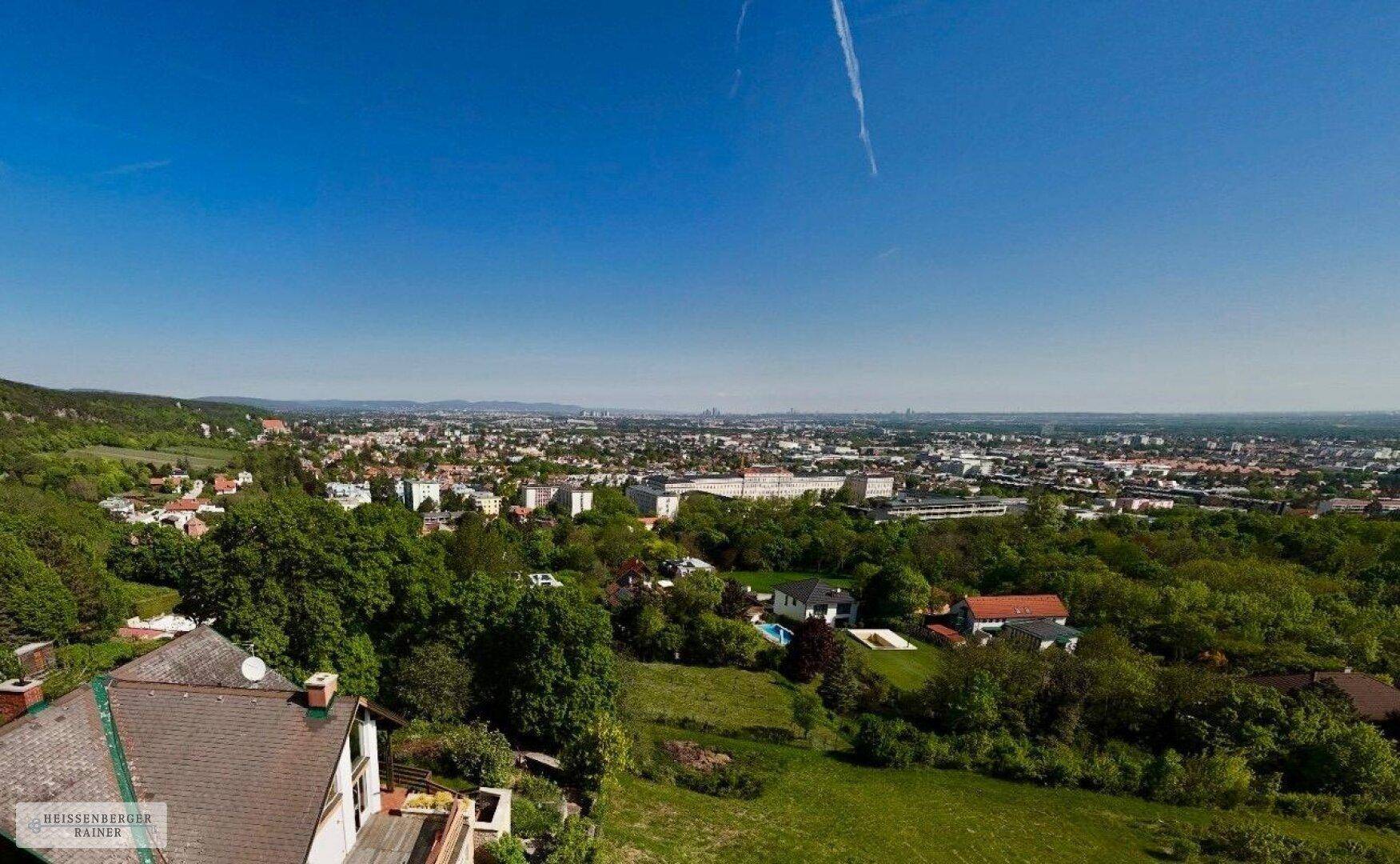 Panoramablick über die Stadt und die umliegende grüne Landschaft von oben.
