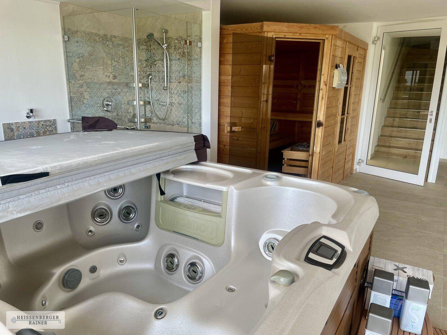 Moderner Wellnessbereich mit Whirlpool, Glasdusche und Saunakabine, hell und einladend.