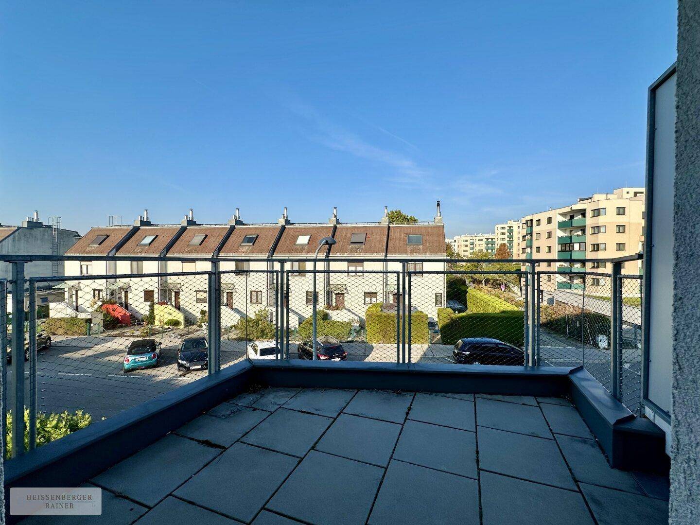 Balkon mit Weitblick über eine ruhige Wohnsiedlung und angrenzende Gebäude.