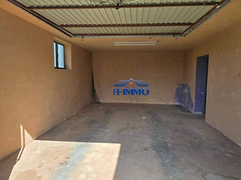 Geräumige Garage mit Betonboden und braunen Wänden, bereit zur Nutzung.