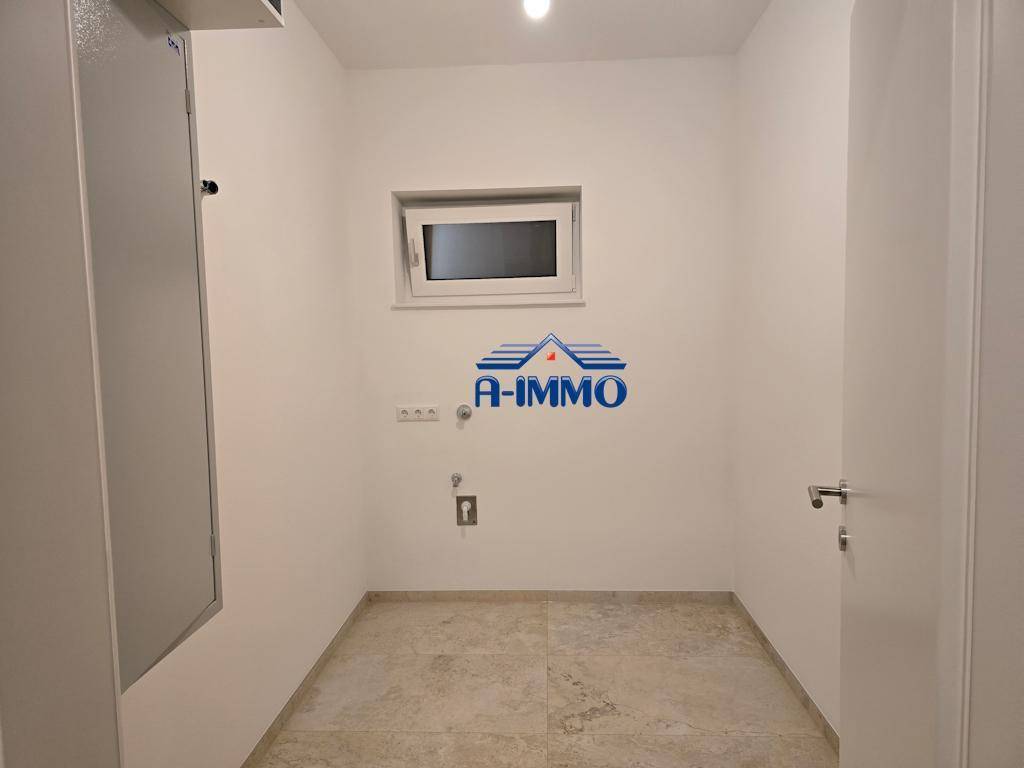 Hauswirtschaftsraum mit Fenster und Anschlüssen für Waschmaschine und Trockner.