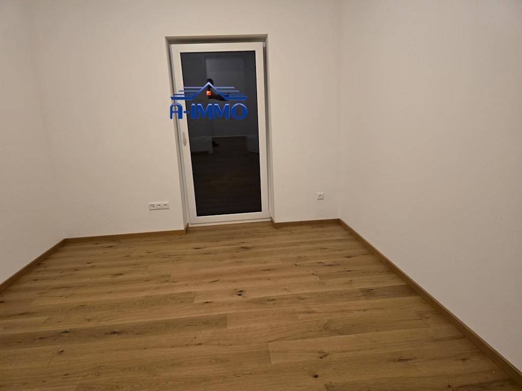 Schlafzimmer mit Holzboden und Zugang zu einem Balkon oder einer Terrasse.