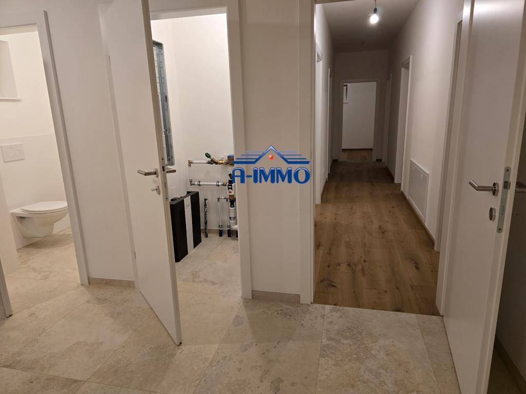 Flur mit Fliesenboden und Zugang zu einem WC sowie einem Technikraum.