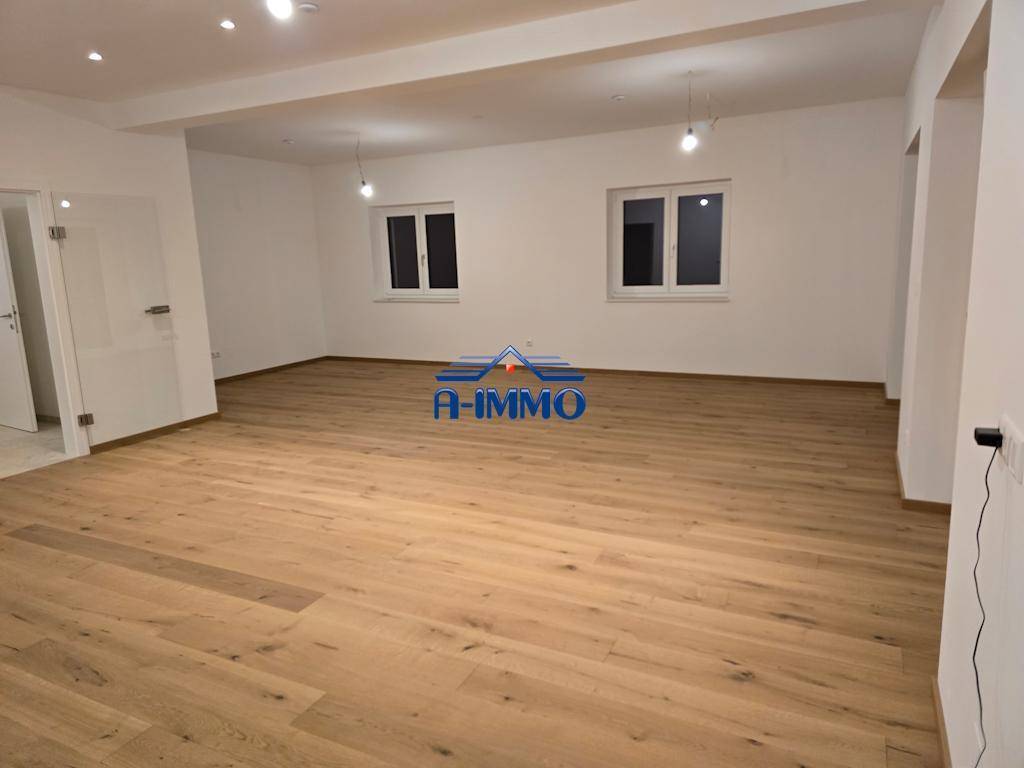Heller Wohnraum mit zwei Fenstern und Holzboden, bietet viel Platz für Einrichtungsideen.